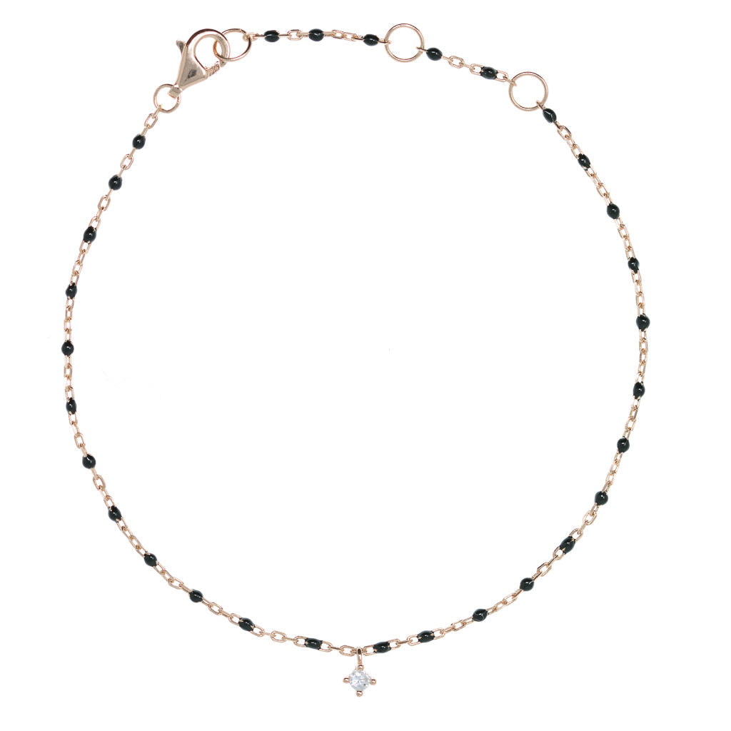 
Rose gold plated chain and bead bracelet with small hanging cubic zirconia, featuring black beads and a lobster claw clasp.

